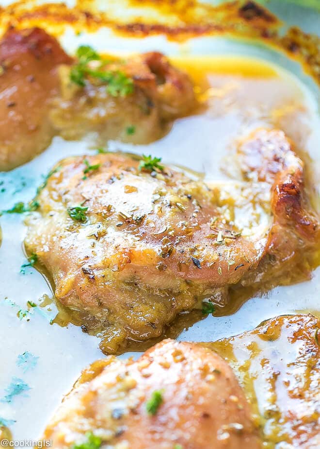 Crispy, juicy, delicious Easy Oven Baked Honey Mustard Chicken Thighs Recipe. In a baking dish with gravy from the sauce.