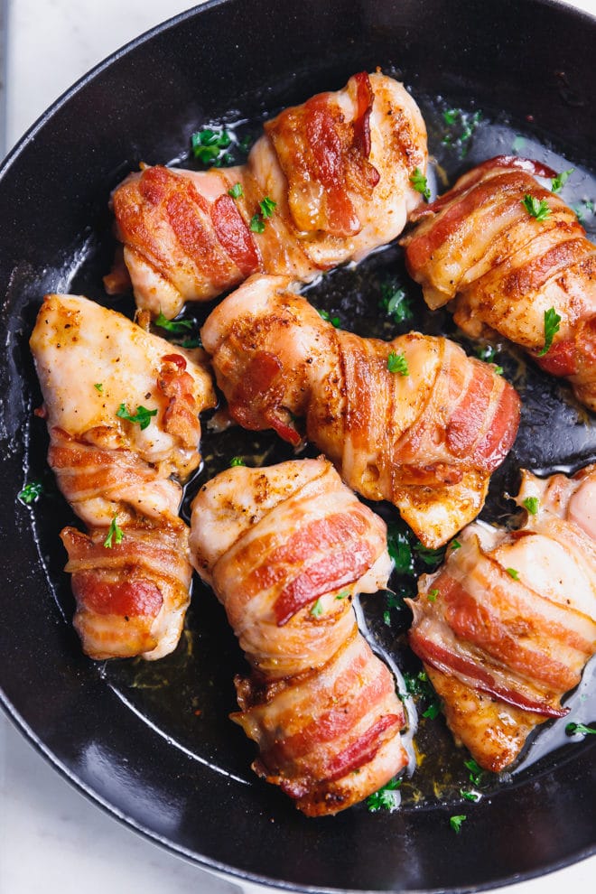 Bacon wrapped chicken thighs in a pan