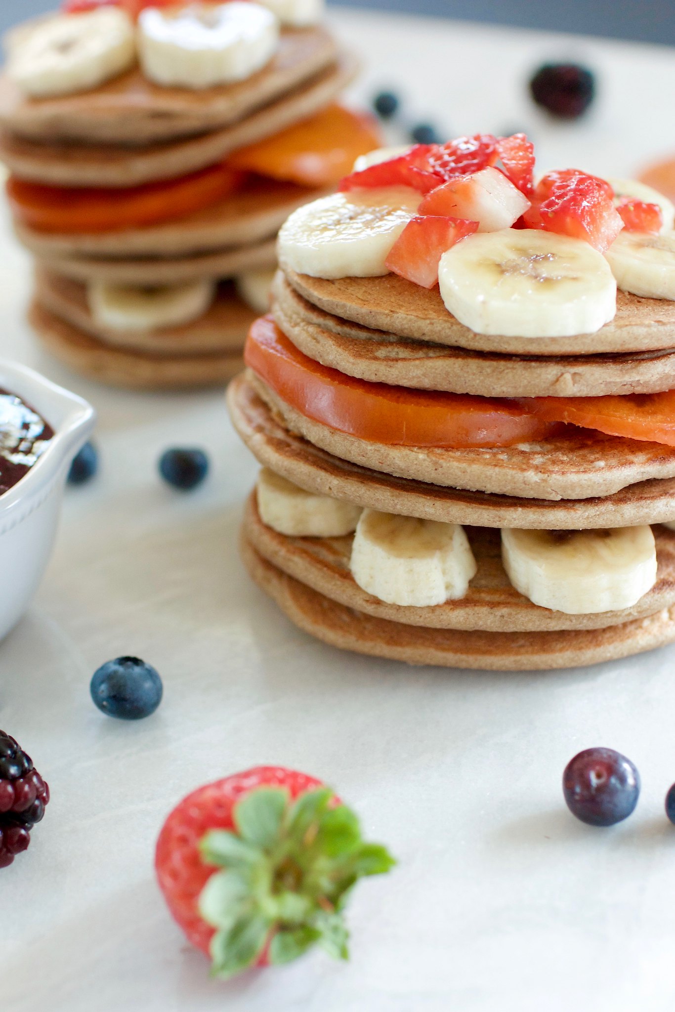 a stright ahead image of healthy 3-ingredient pancakes layered with fruit. 