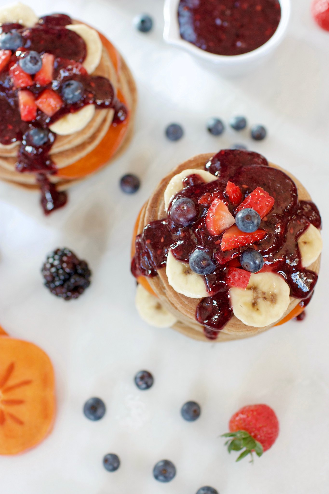 overhead image of Healthy 3-Ingredient Vegan Pancakes topped with berry maple syrup. 