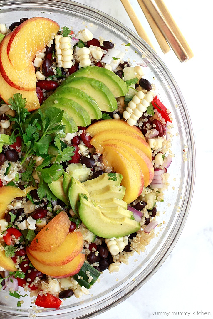 Quinoa salad with black beans, corn, bell pepper, avocado, and peaches. This beautiful vegan quinoa salad is perfect for summer parties or meal prep lunches at home.
